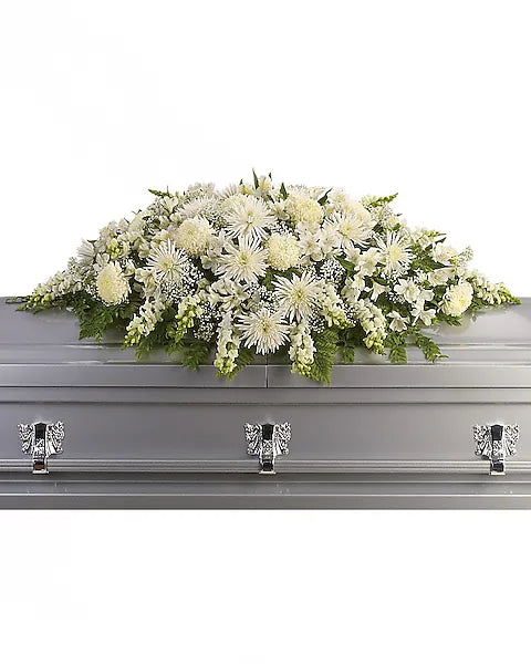 Gray casket with lush white floral arrangement
