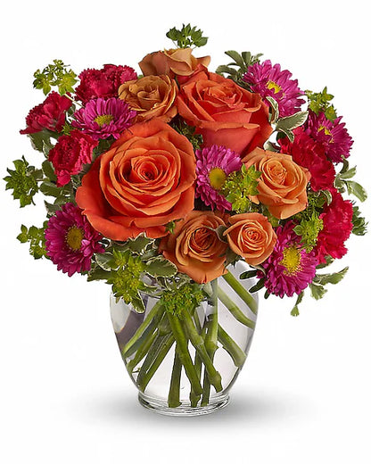 clear glass vase holding a bouquet of vibrant orange and pink flowers.