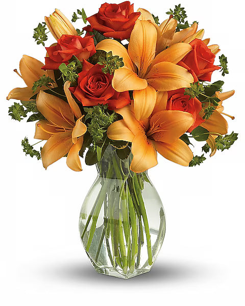 Orange and red flower bouquet elegantly arranged in glass vase