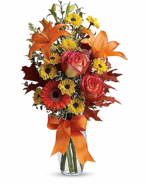 Bouquet of autumn flowers with orange, yellow, and red colors in a glass vase