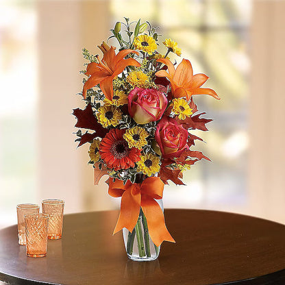 Bouquet of flowers with orange and red colors on a wooden table.